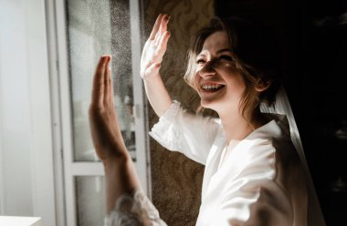 Genç ve güzel bir gelinin portresi. Düğün makyajı. Güzel kız damadı beklerken dairelerde düğün töreni için giyinir ve toplanır. Gelinin sabahı