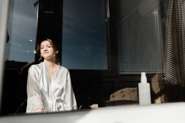 Genç ve güzel bir gelinin portresi. Düğün makyajı. Güzel kız damadı beklerken dairelerde düğün töreni için giyinir ve toplanır. Gelinin sabahı