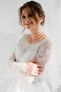 Genç ve güzel bir gelinin portresi. Düğün günü toplantıları. Güzel kız damadı beklerken dairelerde düğün töreni için giyinir ve toplanır. Gelinin sabahı