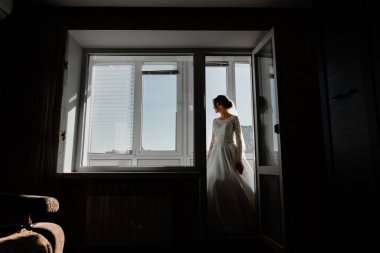 Balkonda genç ve güzel bir gelinin portresi. Düğün günü toplantıları. Güzel kız damadı beklerken dairelerde düğün töreni için giyinir ve toplanır. Gelinin sabahı