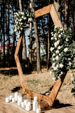 Çiçek açan düğün kemeri, güller, ortanca ve okaliptüs. Düğün ahşabı süslemesi. Çiçeklerle, yeşillikle ve salon alanıyla süslenmiş ahşap tahta. Düğün fotoğrafı bölgesi. Parti alanı kırsal tarzı.
