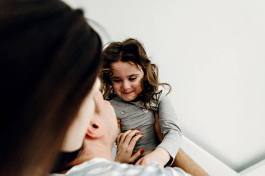 Sabahları mutlu bir ailenin portresi, pijamalı bir aile, aile fotoğrafı, kameraya pijamayla poz veren mutlu bir aile, anne ve kız hatıra olarak fotoğraf çekiyorlar.