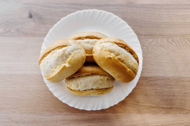 Tabakta ekmek, fast food 'a hazırlanmak için ekmek, tereyağı için sandviç, fast food yağı masadaki mutfak gereçlerinde yatıyor.