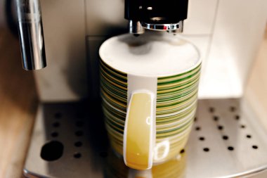 Evde kahve makinesi bir fincan kahve doldurur, adamın eli kahve makinesinin başlama düğmesine basar, sıcak kahve bardağa dökülür, evde kahve...