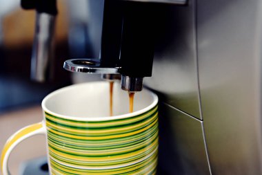 Evde kahve makinesi bir fincan kahve doldurur, adamın eli kahve makinesinin başlama düğmesine basar, sıcak kahve bardağa dökülür, evde kahve...