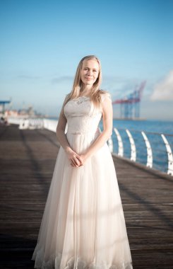 Gelinlik giymiş mutlu gelin, gelinlik giymiş gelin, genç spor çantası denizin arka planında bir gelinlik içinde dönüyor, gelinin sabah fotoğraf çekimi, gelin portresi