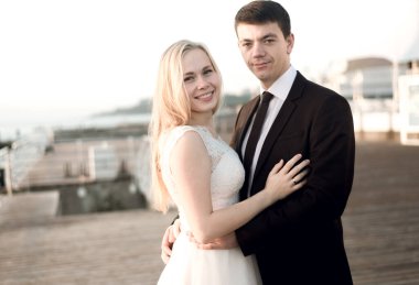 Gelin ve damadın portresi, denizin arka planında yeni evliler, deniz kıyısında mutlu bir çift, yeni evliler törenden sonraki gün sarılıyorlar, gelin ve damadın gelinlikleri, düğün günü.