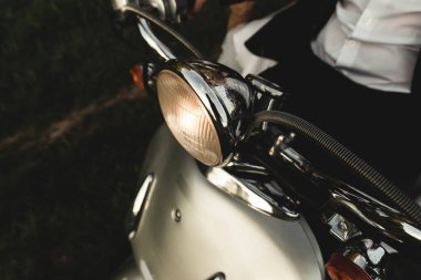 Düğün damadı ve gelin motosiklet sürüyor, eğleniyor, gülümsüyor düğün çifti gün batımında şehir dışındaki yolda scooter 'a biniyor, düğün çifti scooter' a biniyor, yeni evliler dekore edilmiş scooterla eğleniyor, bulanık yeni evliler.