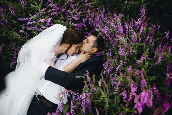 Par Vid Solnedgången Bröllopsklänning Ligger Gräset Med Lipin Blommor Festlig — Stockfoto