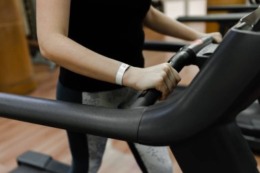Spor üniformalı genç bir kız spor salonundaki koşu bandında koşuyor, bir kız boş bir spor salonunda, kız spor salonunda kilo veriyor.