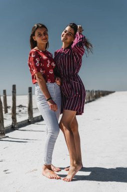 Mutlu kız arkadaşlar ayağa kalkar ve doğada sarılırlar, şık giyinmiş Avrupalı kızlar, genç kızlar sıcak bir yaz gününde yürürler, güzel bir arka planda genç insanlar gülümser ve hayattan zevk alırlar, kız kardeşler sarılır, genç ve mutlu en iyi arkadaşlar, genç kız kardeşler