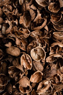 Karşıt arkaplanda ceviz kabuğunun üst görüntüsü, çok sayıda soyulmuş ceviz kabuğu, ceviz dokusu