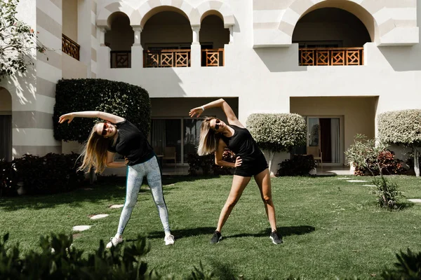 Dos Chicas Deportistas Están Estirando Césped Cerca Casa Estilos Vida — Foto de Stock