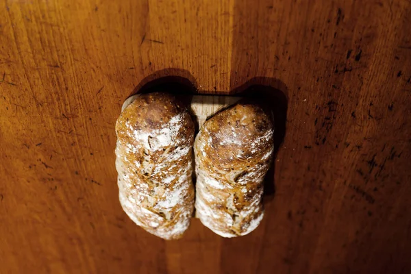 焼きたてのパンを木のテーブルの上に寝そべって2つのパンはまな板の上に寝そべって — ストック写真