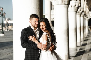 Düğün günü, yeni evliler eski şehrin sokaklarında sarılırlar, düğün yürüyüşü, aile kurmak, şık bir düğün fotoğrafı çekimi.