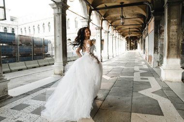 bride in motion,running bride,beautiful bride in a wedding dress walks in the old city,happy bride after the ceremony,bride at the wedding day clipart