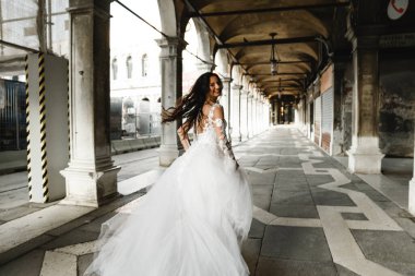 bride in motion,running bride,beautiful bride in a wedding dress walks in the old city,happy bride after the ceremony,bride at the wedding day clipart