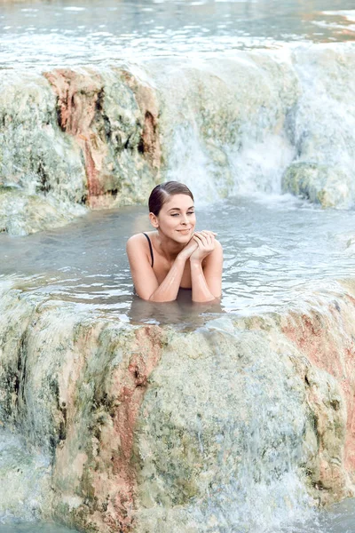 Pretty young brunette woman taking a bath in the natural thermal — Stock Photo, Image