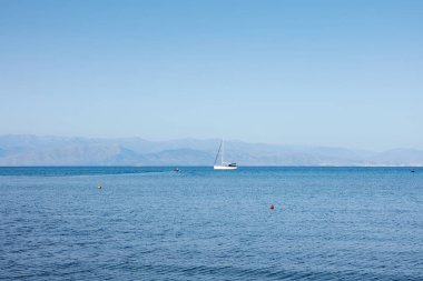 Yalnız yat ufukta, Corfu Island, Yunanistan ile denizde fantastik deniz görünümü. Güneşli bir gün, minimalizm, sakin ve sessiz.