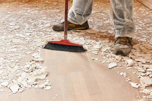 Builder sweeping the floor after renovation