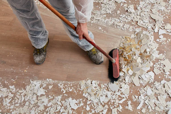 Builder sweeping the floor after renovation — Stock Photo, Image