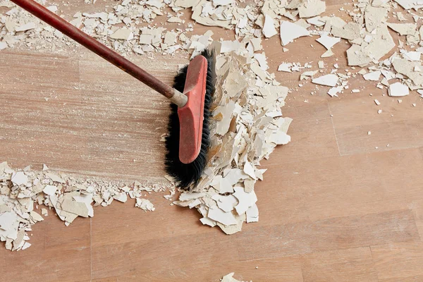 Builder sweeping the floor after renovation Royalty Free Stock Photos