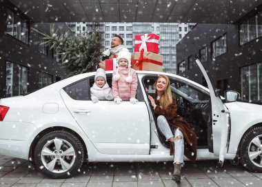 Yeni yıl hediyeleri ve Noel ağacı olan mutlu bir aile. Baba, annem ve iki kızım Noel tatiline arabayla gidiyorlar. Xmas alışveriş ve hazırlık