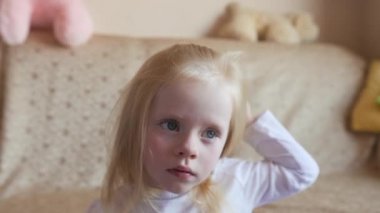 Saçlarını tarayan küçük sarışın kız.