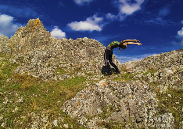 Ung dam i yoga position på klipporna — Stockfoto