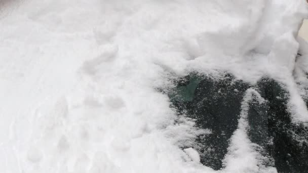 Человек очищает машину от снега — стоковое видео