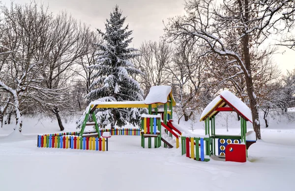 Детская площадка, покрытая снегом — стоковое фото