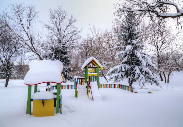 Parco giochi per bambini coperto di neve — Foto Stock