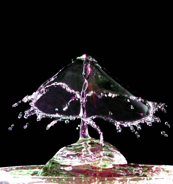 Colorful liquid splash on black background — Stock Photo, Image