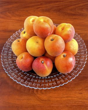 Ahşap arka plan üzerinde plaka üzerinde olgun kayısı