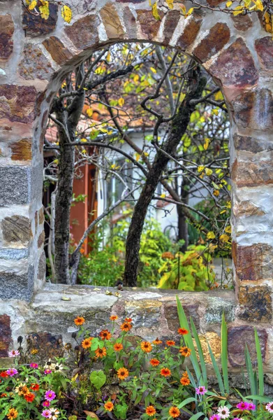 Κομψό πέτρινο τοίχο και πολύχρωμα λουλούδια — Φωτογραφία Αρχείου