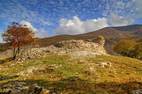 Paisagem montanhosa com ruínas da antiga fortaleza e árvores coloridas de outono — Fotografia de Stock