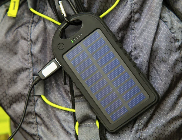 Портативный солнечный элемент висит на туристическом рюкзаке Лицензионные Стоковые Фото