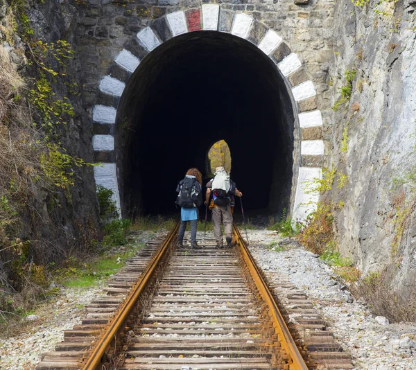 Tourists with backpacks on railroad track