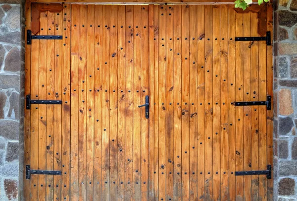 Деревянные двери с металлическими орнаментами на каменной стене — стоковое фото