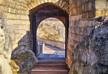 Antik bir kalenin açık taş kapısından bir bakış.