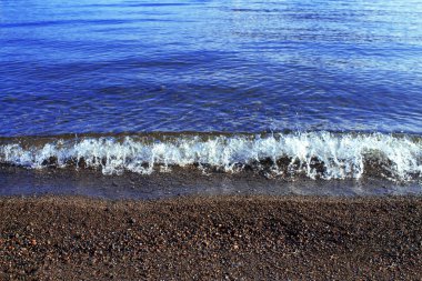 Güzel sahil, küçük dalgalar ve sarı kumlar