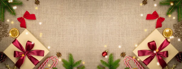 Feliz Navidad y Felices Fiestas tarjeta de felicitación, marco, bandera. Año Nuevo. Noel. Navidad adornos rojos, verdes y amarillos y regalo sobre fondo de lino vista superior. Vacaciones de Navidad de invierno theme.Flat lay — Foto de Stock