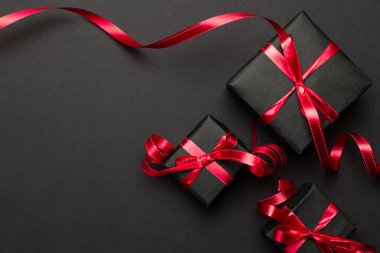 Xmas geçmişi. Kırmızı Noel hediyeleri, siyah arka plan manzaralı süsler. Kış tatili hediyesi. Mutlu Noeller ve mutlu bayramlar tebrik kartı, çerçeve, pankart. Yeni yıl. Noel. Düz yatıyordu