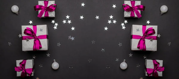 Nieuwjaarsachtergrond. Kerstcadeaus met rood lint op zwart b — Stockfoto