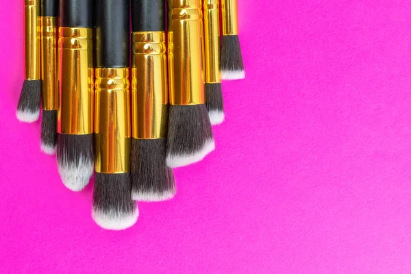 Pink background. Makeup brushes isolated on pink with copy space