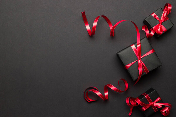 Xmas gift. Christmas gifts, red decor on black background top view. Winter xmas holiday. Merry Christmas and Happy Holidays greeting card, frame, banner. New Year. Noel