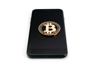 Kripto para birimi geçmişi. Telefonu beyaza izole edilmiş altın Bitcoin. Para kavramı