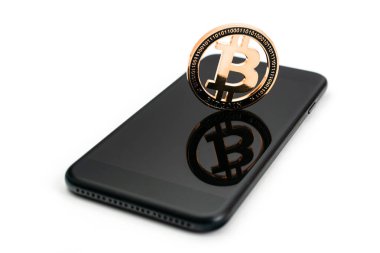 Biraz bozuk para. Altın kripto para birimi, beyaz arka planda izole edilmiş siyah akıllı telefon. Litecoin, Ethereum Crypto Cash