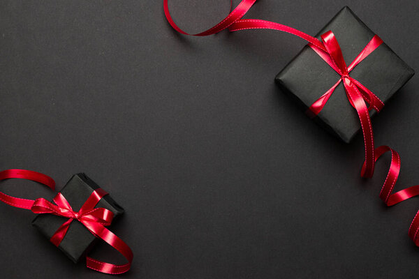 Xmas gift. Christmas gifts, red decor on black background top view. Winter xmas holiday. Merry Christmas and Happy Holidays greeting card, frame, banner. New Year. Noel