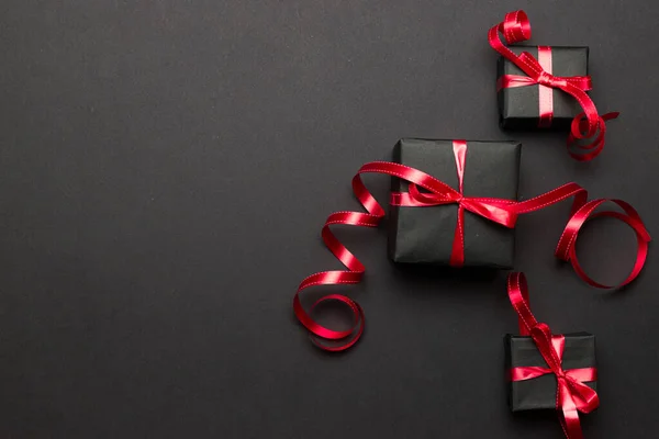 Лента подарочной коробки. Рождественские подарки, красный декор на черном фоне. Рождественский подарок. Концепция зимнего отдыха. Новый год. Ноэль . — стоковое фото